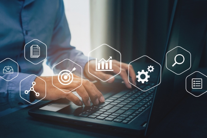 Geschäftsmann arbeitet am Laptop mit eingeblendeten Symbolen für Datenanalyse und digitales Marketing.