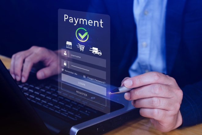 Online payment form on laptop screen with hands using digital pen for secure transaction.