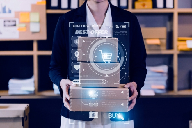 Person holding stacked boxes with shopping cart graphic overlay for online order fulfillment.