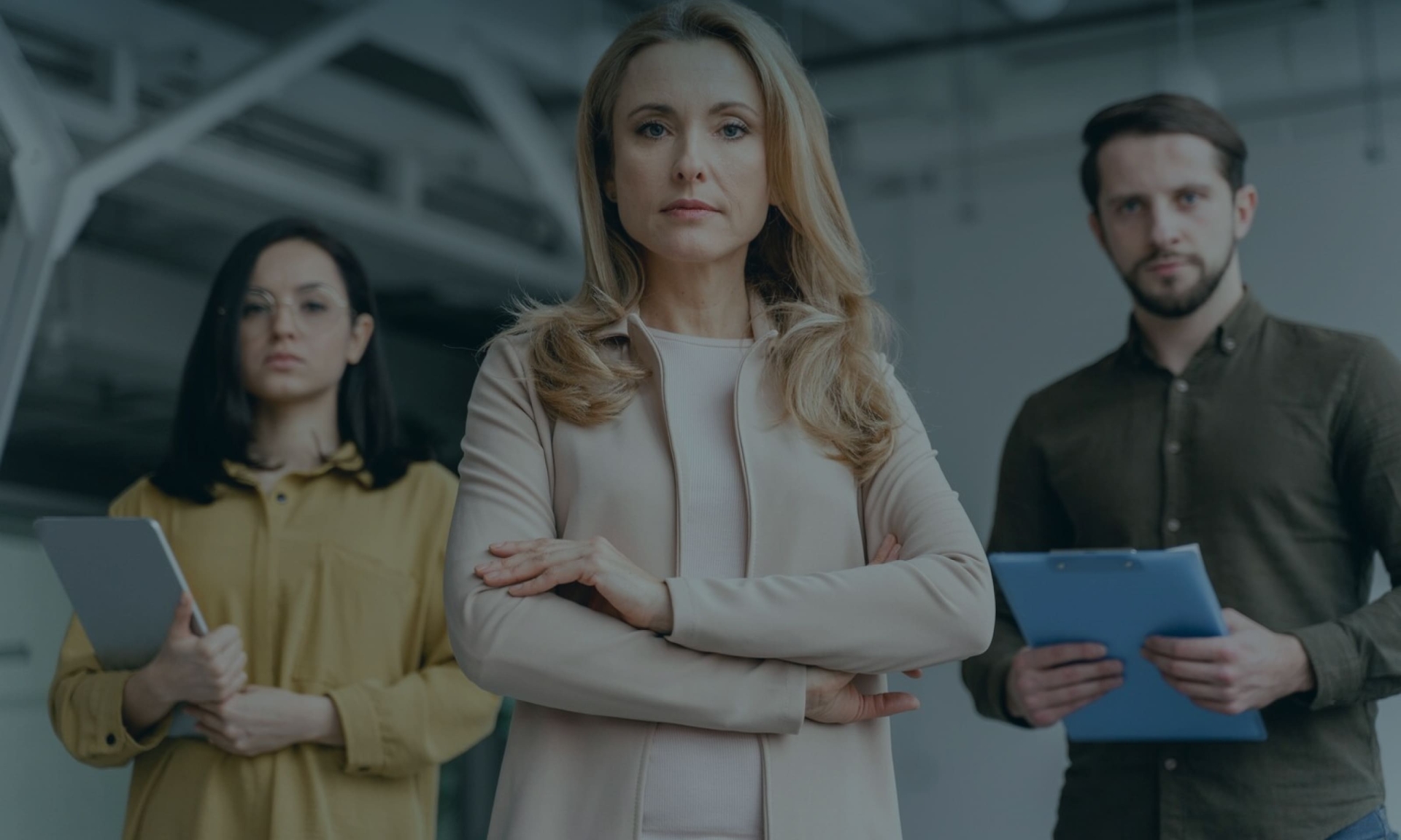 Selbstbewusstes Business-Team: Führungsfrau mit diversen Kollegen und Kolleginnen, die Tablets in einem modernen Büro halten.