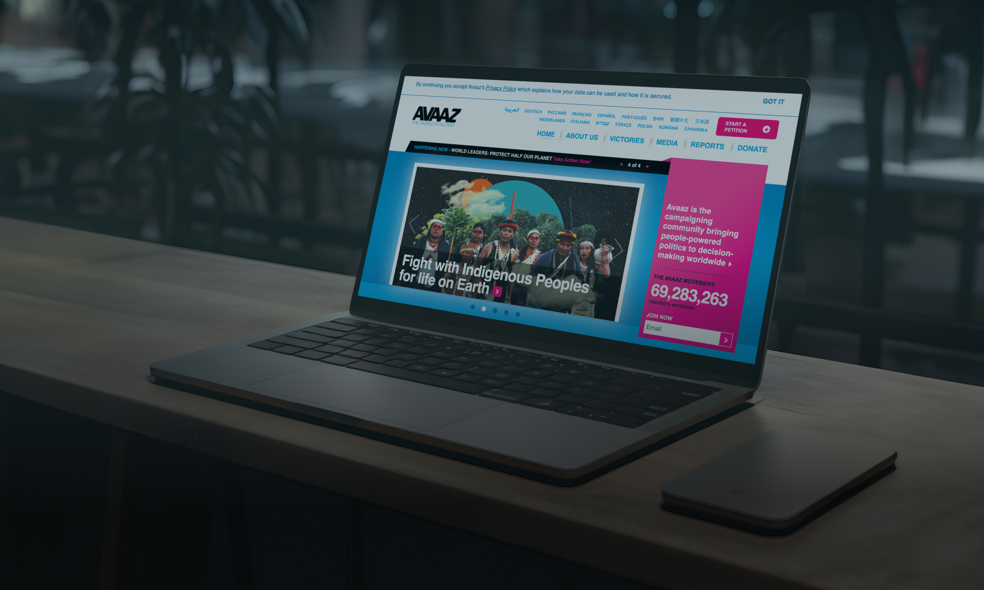 Laptop displaying the ANZ Bank website on a wooden surface near a window.