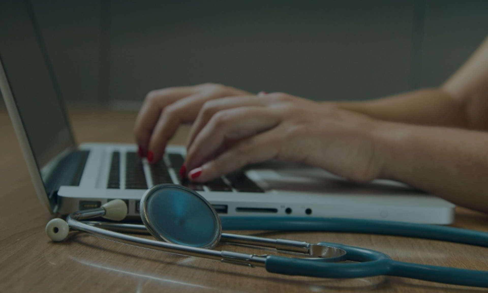 Arzt tippt auf Laptop mit Stethoskop. Telemedizin, Gesundheitswesen und medizinisches Fachpersonal Konzept.