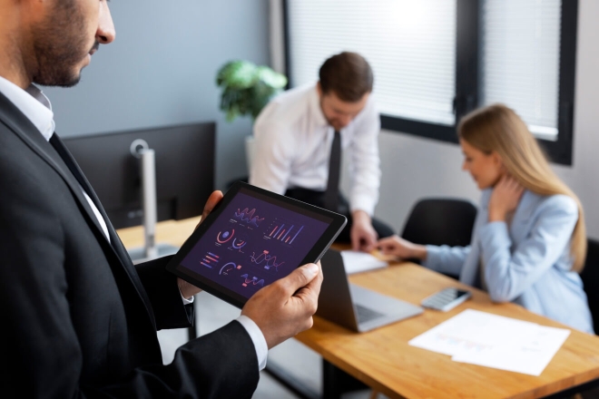 Ein Business-Team analysiert Finanzdaten auf einem Tablet während einer Bürobesprechung. Investitionsstrategie.