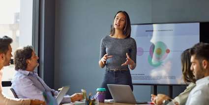 Businesswoman presenting data charts to colleagues during a corporate meeting.