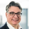 Professionelles Porträt eines reifen Mannes mit Brille im Sakko, Business-Porträt.