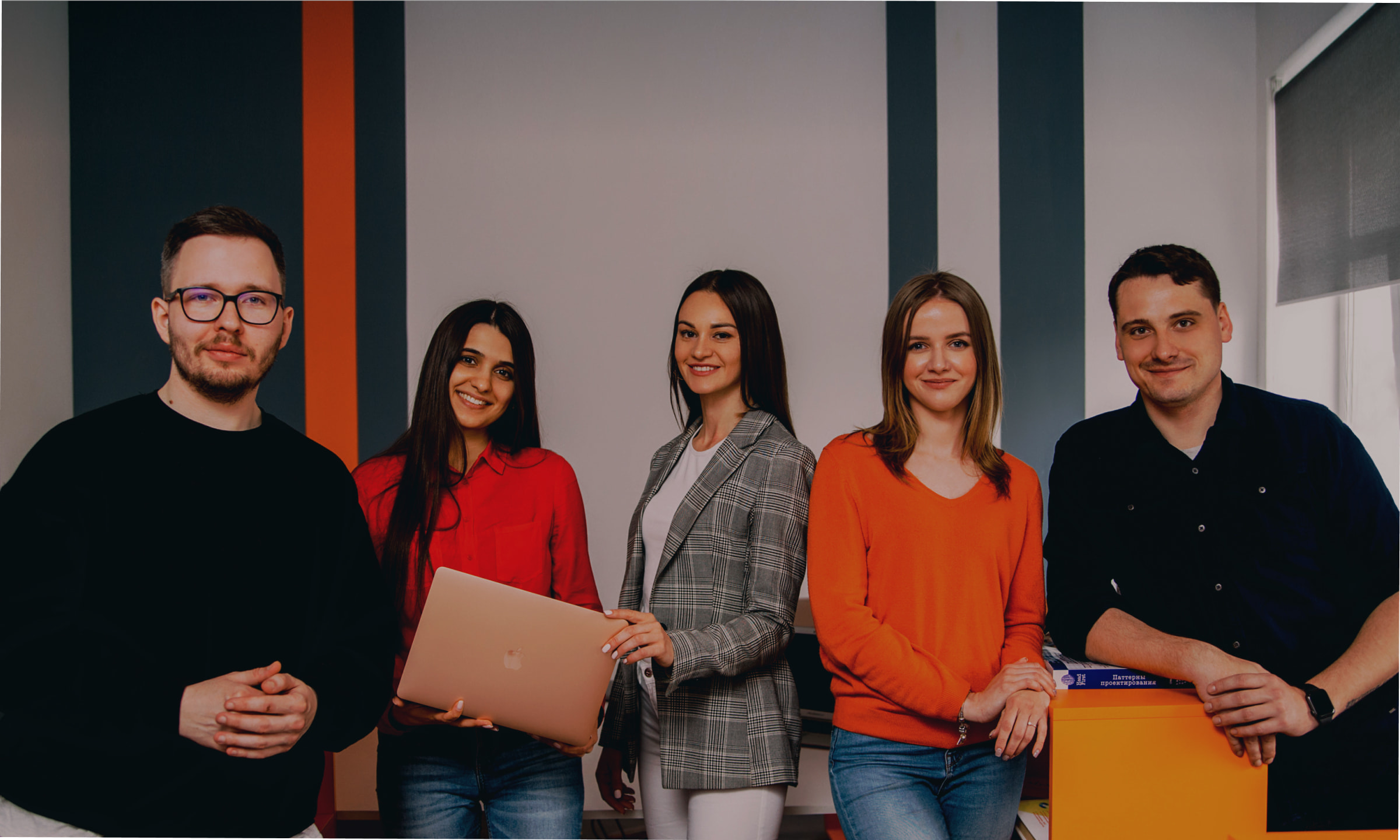 Diverse team portrait: Five smiling professionals in a modern office environment. Business, collaboration, workplace.