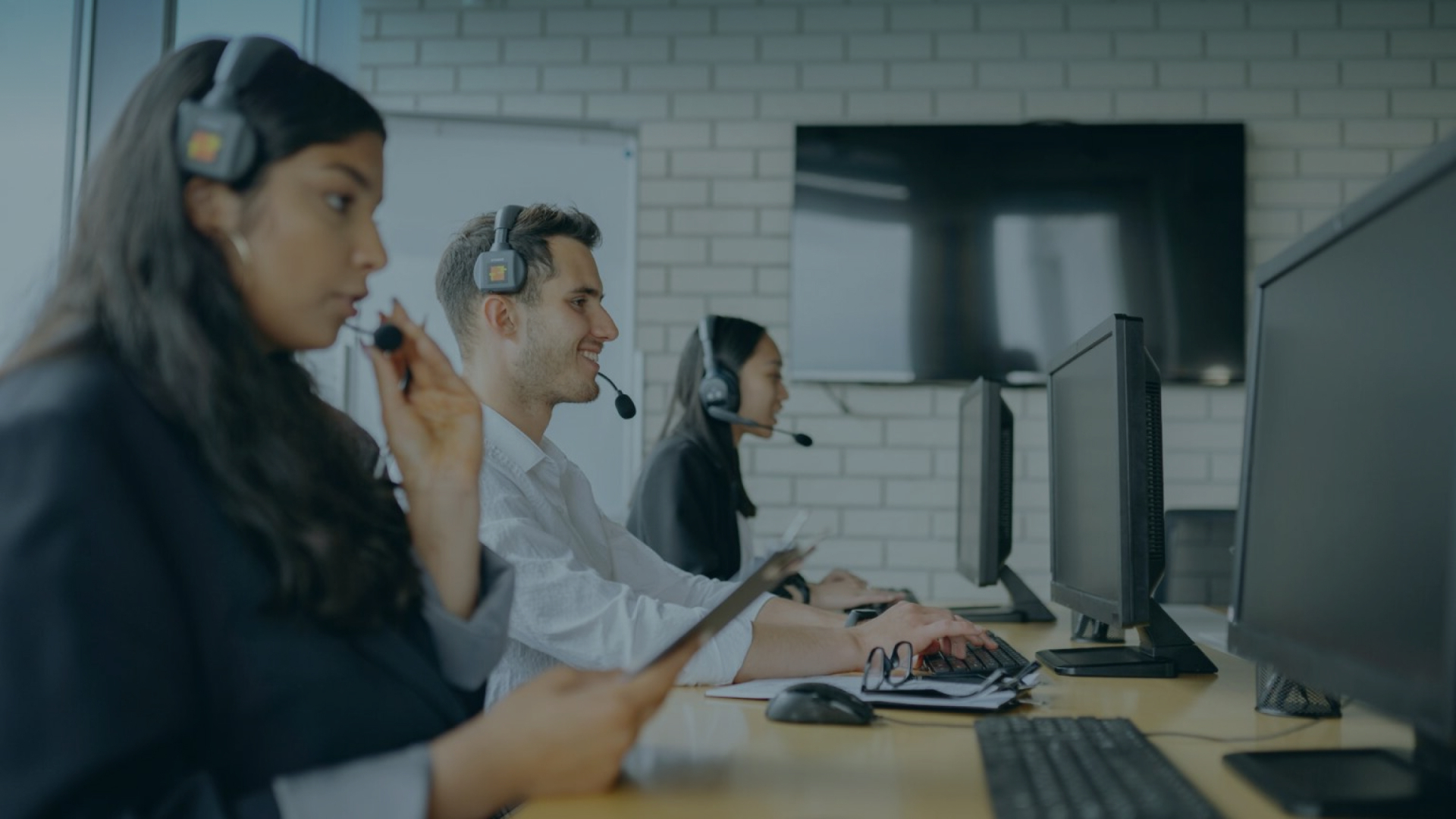 Callcenter-Team: Vielfältiges Kundendienstteam mit Headsets an Computerarbeitsplätzen.