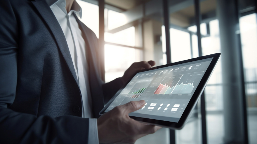 Ein Geschäftsmann im Anzug analysiert Finanzdaten und Börsencharts auf einem Tablet-Computer.
